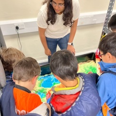 Team member showing an interactive contour map sandbox to children